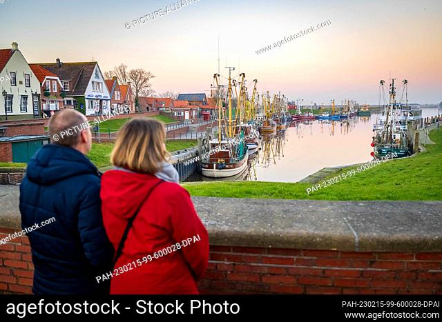 PRODUCTION - 14 February 2023, Lower Saxony, Greetsiel: Tourists look at the shrimp cutters at the harbor. The new North Sea Tourism Agency (Tano) wants to...