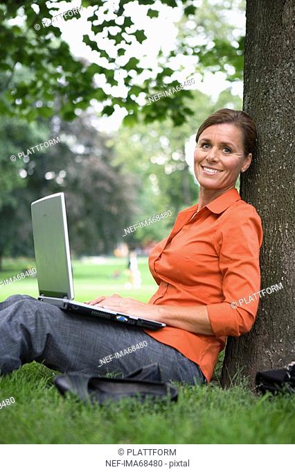 A woman in a park using a laptop Sweden