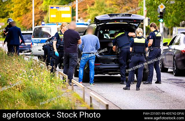 01 October 2023, Lower Saxony, Hanover: Police officers check participants of a wedding procession and their vehicles. Passers-by reported hearing shots coming...
