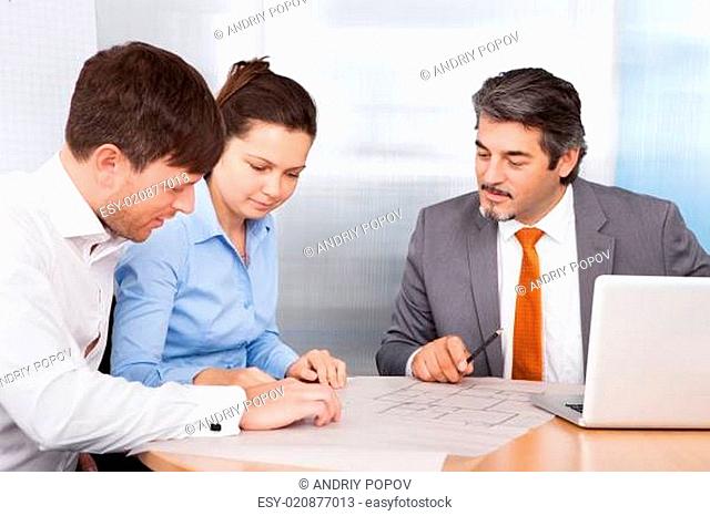 Broker Explaining To Young Couple