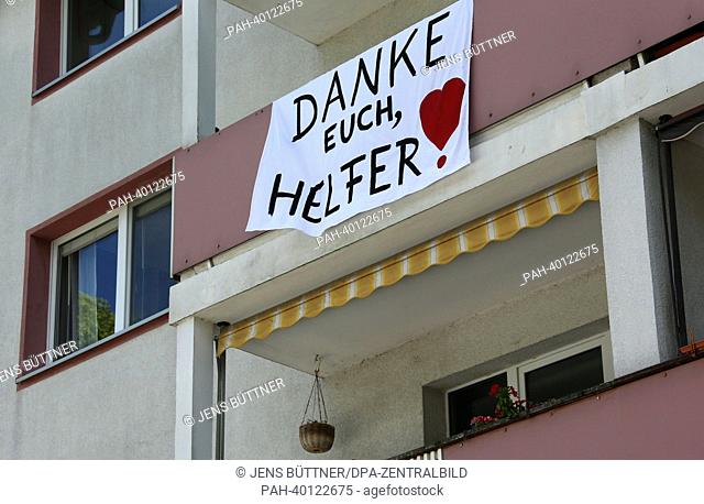 A self bade banner with the lettering 'Thank You Dear Helpers' hangs from a balcony of an evacuated apartment building in in Magdeburg, Germany, 10 June 2013