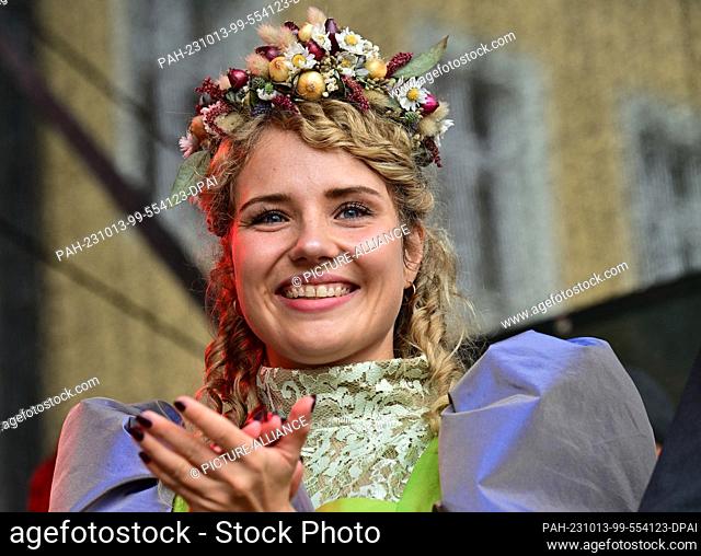 13 October 2023, Thuringia, Weimar: Laura Palko stands as Weimar's Onion Market Queen Laura I on the market square. The 370th Weimar Onion Market begins on...