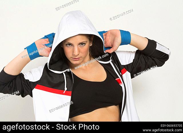 Junge Sportlerin trägt Trainingsjacke mit Kapuze