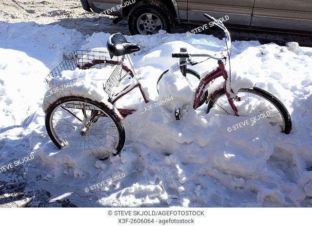 Three wheel bicycle stranded in winter snow bank. St Paul Minnesota MN USA
