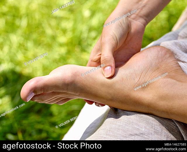 Barefoot walking - close-up with foot and hand from grip technique to foot reflexology massage