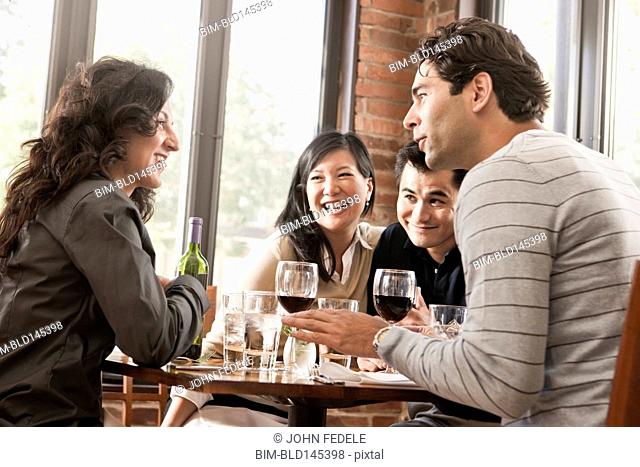 Friends drinking red wine together in restaurant