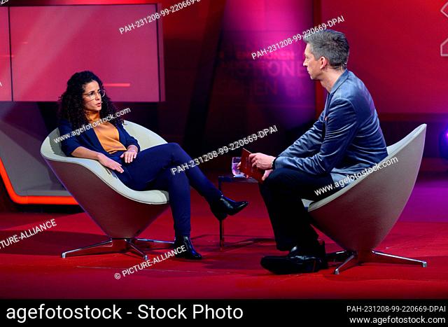 08 December 2023, North Rhine-Westphalia, Hürth: Israeli Dafna Gerster (l) and presenter Steffen Hallaschka (r) sit in the studio for RTL's annual review ""2023