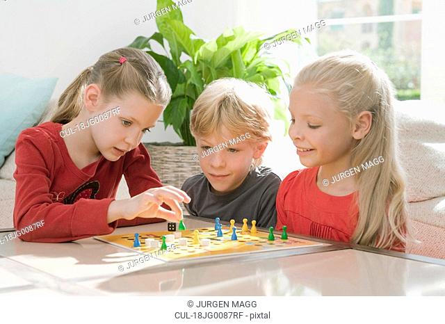 Three children playing a board game