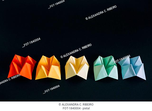 Rainbow multicolored origami fortune tellers on black background