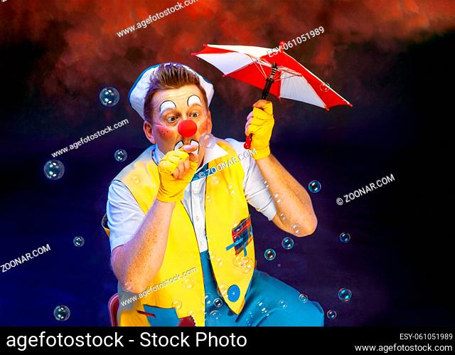A funny clown with smiling joyful expression , at colored background