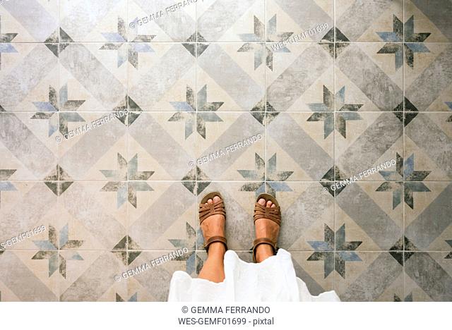 Woman standing on ornate tiled floor