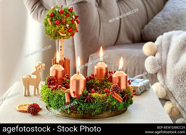 Advent wreath made of moss, cinnamon sticks and rosa canina twigs. Festive decor
