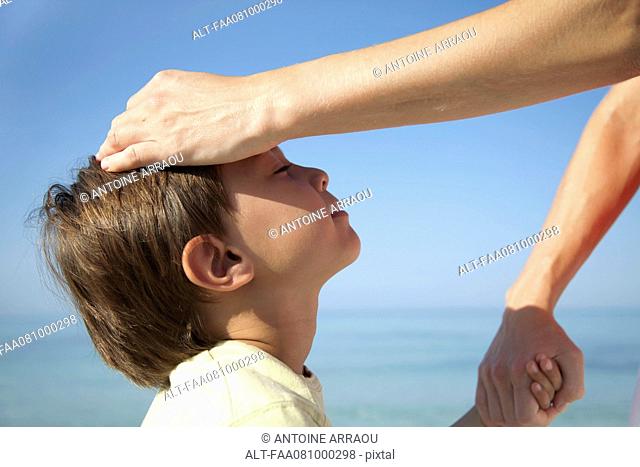 Mother's hand on boy's head