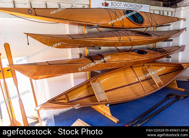19 May 2022, Mecklenburg-Western Pomerania, Peenemünde: Different boat models from the work store hang in the small shipyard