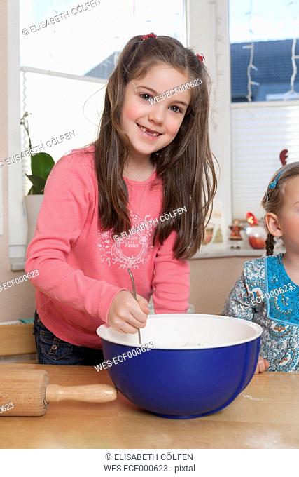Portrait of little girl stirring dough