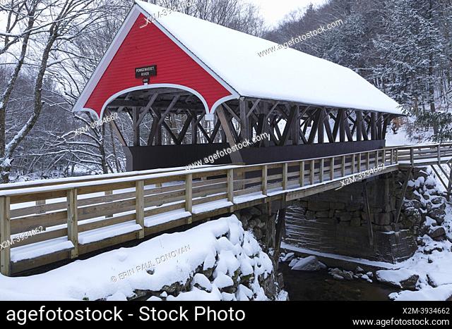 The Flume Covered Bridge in Franconia Notch State Park in Lincoln, New Hampshire covered in snow on an autumn morning. This picturesque bridge crosses the...