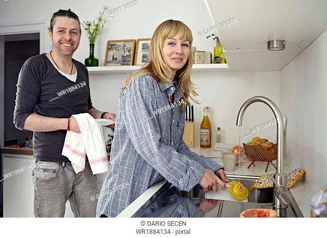 Couple Washing Up In Kitchen
