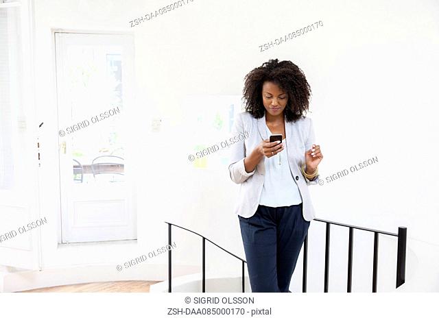 Businesswoman text messaging on cell phone