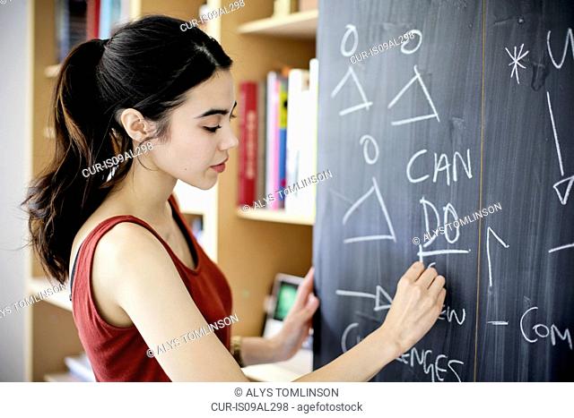 Woman writing on blackboard
