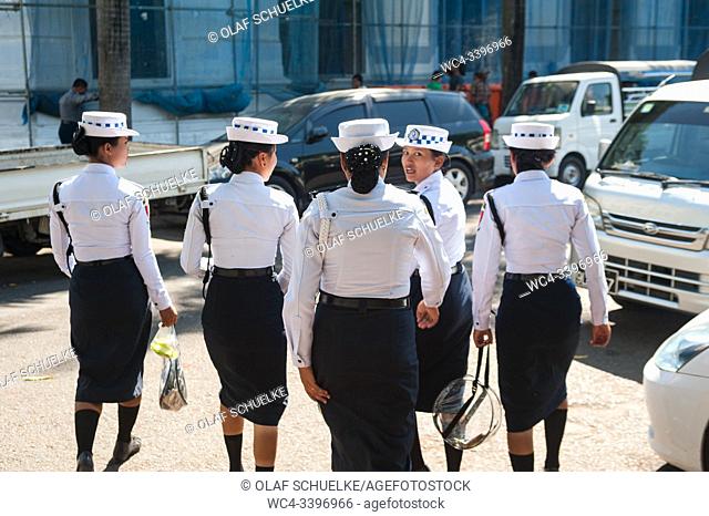 Yangon, Myanmar, Asia - A group of female traffic police officers walks down a road in the centre of the former capital
