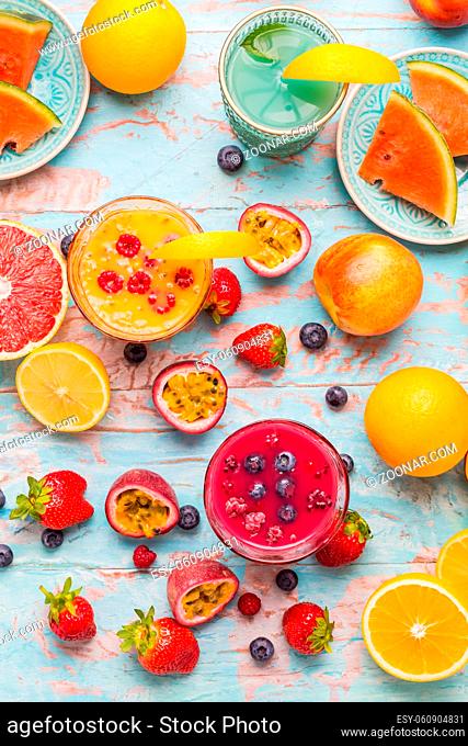 Variation of smoothies and refreshing drinks with fresh fruits for hot summer on blue background