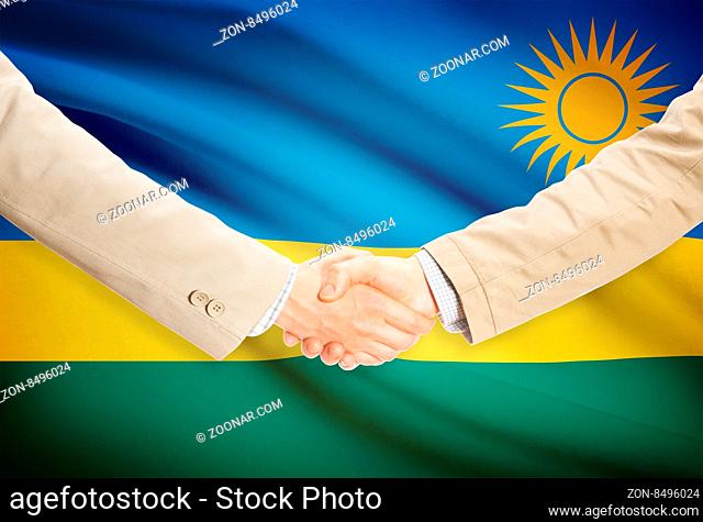 Businessmen shaking hands with flag on background - Rwanda
