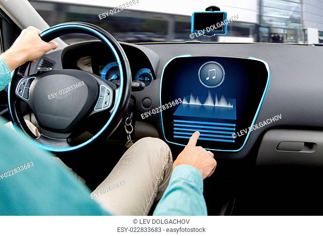 transport, modern technology, music and people concept - close up of man driving car with audio stereo system on board computer