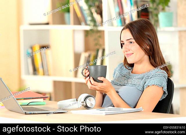 Relaxed student resting drinking coffee contemplating sitting at home