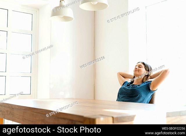 Young woman at table at home relaxing