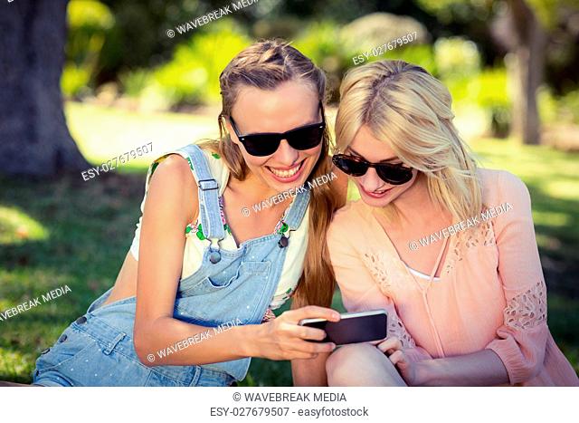 Woman showing mobile phone to her friend