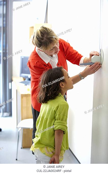 Doctor measuring height of young girl