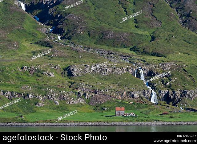 Remote farm in front of a waterfall, Seyðisfjörður, Austurland, East Iceland, Iceland, Europe