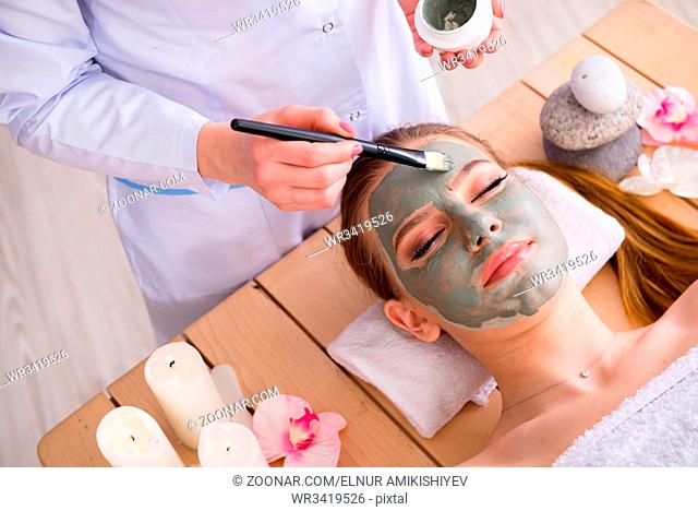 Young woman in spa health concept with face mask