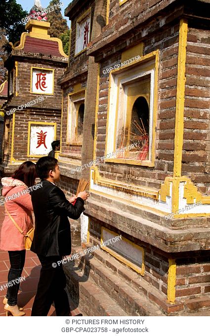 Vietnam: Placing incense sticks at the Tran Quoc Pagoda (Tran Quoc Buddhist temple), Ho Tay (West Lake), Hanoi