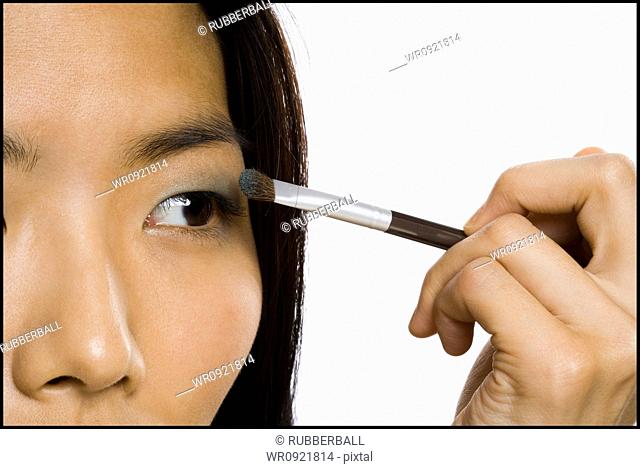 Woman applying eyeshadow with makeup brush