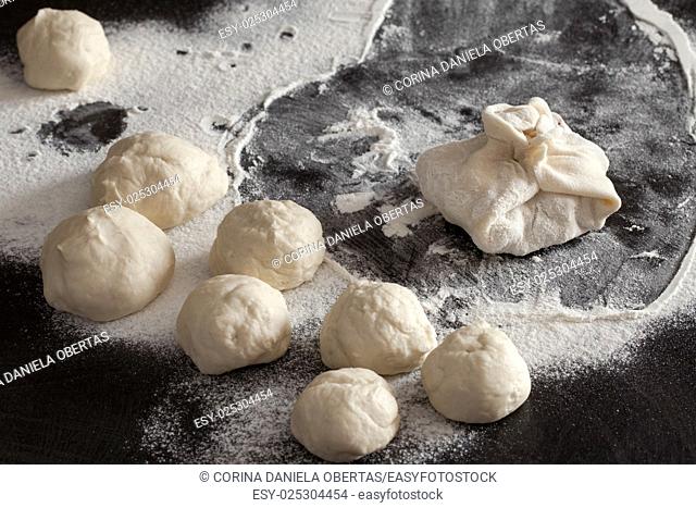 Raw dumpling and dough balls to prepare it on lightly floured table