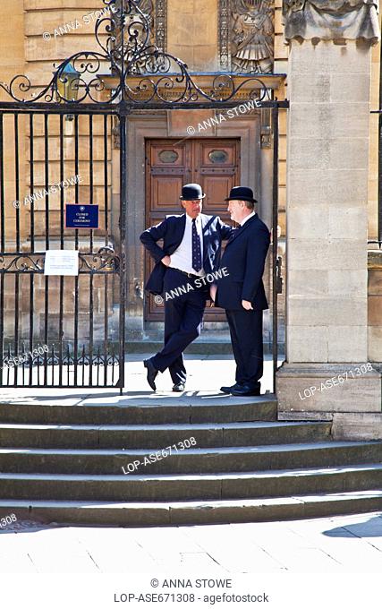 England, Oxfordshire, Oxford. Two Oxford bulldogs in traditional bowler hats outside the Sheldonian Theatre at Oxford University