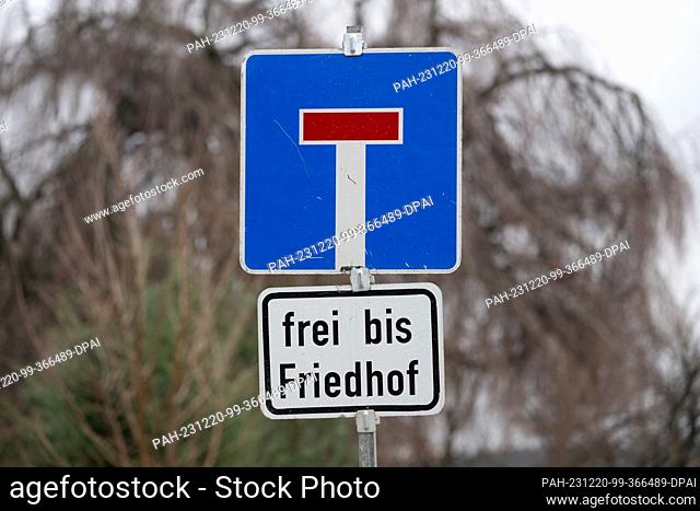 PRODUCTION - 20 December 2023, Saxony, Großröhrsdorf: A traffic sign ""dead end"" and an additional sign ""free to cemetery"" are located on the road to the...