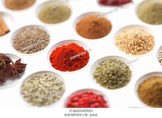 Variety of spices in bowls, focus on paprika powder, close-up