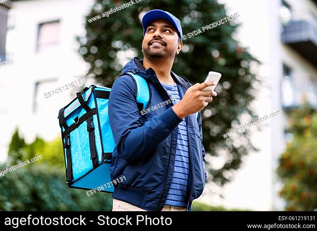 smiling indian delivery man with bag and phone