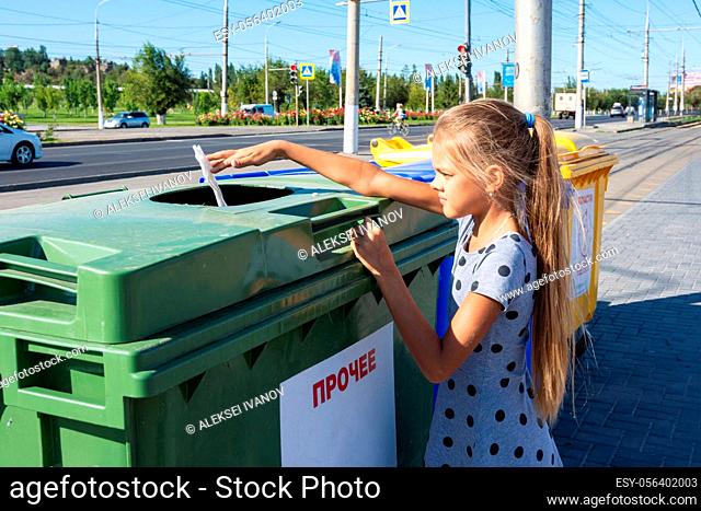 Girl throws a napkin into the trash bin