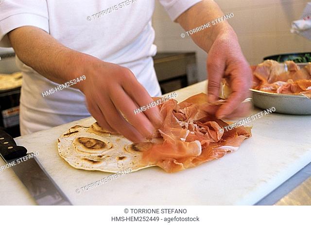 Italy, Emilia-Romagna, Rimini, Casina del Bosco Restaurant, preparing the piadina, local Italian bread cooked in a frying pan