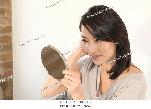 Korean woman looking in mirror