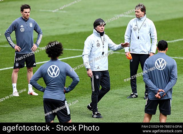 29 May 2021, Austria, Seefeld: Football: National team, training camp, training. National coach Joachim Löw (M) speaks to the players on the training pitch...