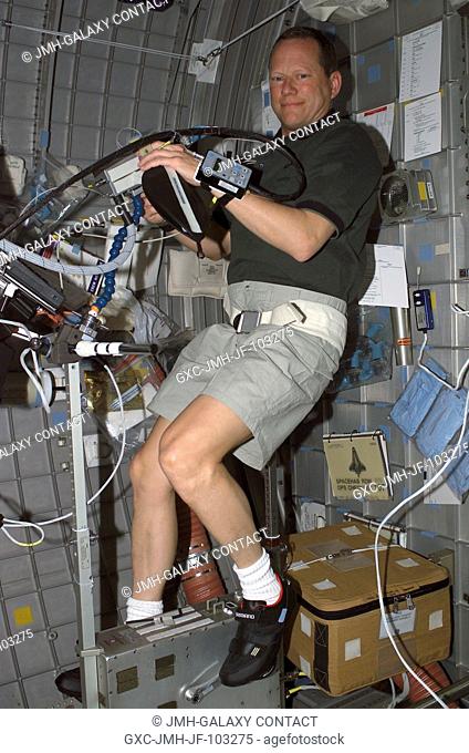 Astronaut David M. Brown, STS-107 mission specialist, participates in an experiment requiring the use of the bicycle ergometer in the SPACEHAB Research Double...