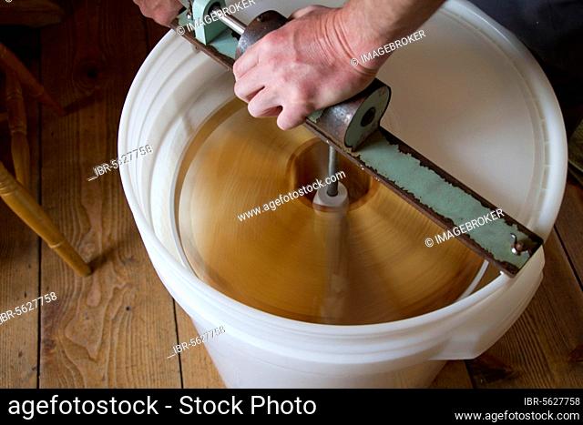 The honeycomb frames are placed in a centrifugal drum and then spun at high speed to separate the honey from the combs
