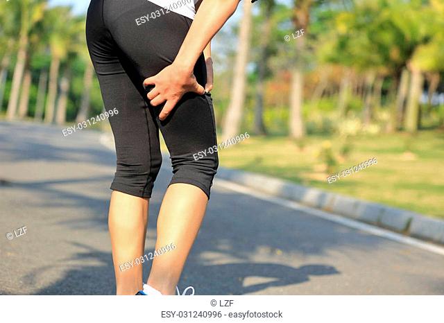 woman runner hold her sports injured leg