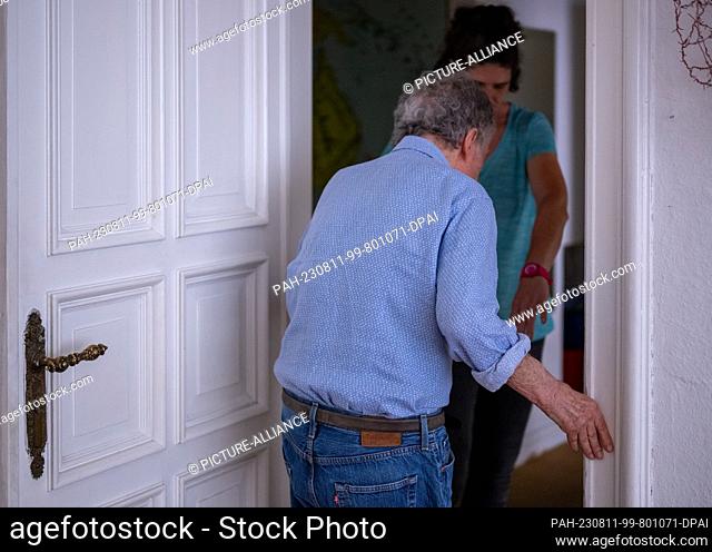 PRODUCTION - 31 July 2023, Berlin: During a home visit, nurse Ramona Rössner helps her patient Andreas Seltzer, who is in need of care, to walk