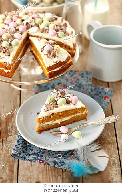 Carrot cake with orange cream and chocolate eggs for Easter