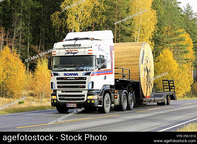 Scania R500 truck Kuljetus Karru Oy transports large wooden Prysmian Group cable reel on gooseneck trailer along road. Salo, Finland. October 11, 2019